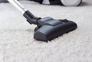 Hello Maids team member vacuuming a customer’s carpet in Southwest Florida home